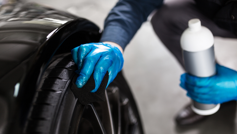 Tyre fitter polishing car tyres
